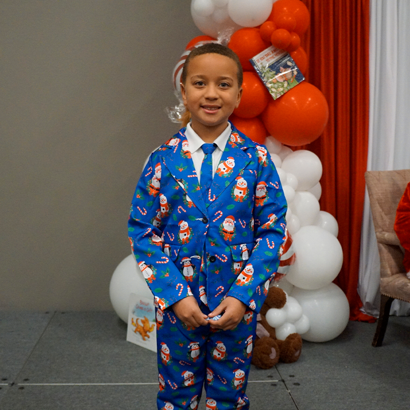 Young boy in a blue Santa suit and tie