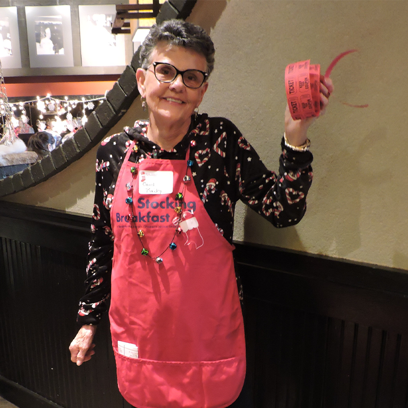 KCSL Red Stocking Breakfast volunteer holding raffle tickets